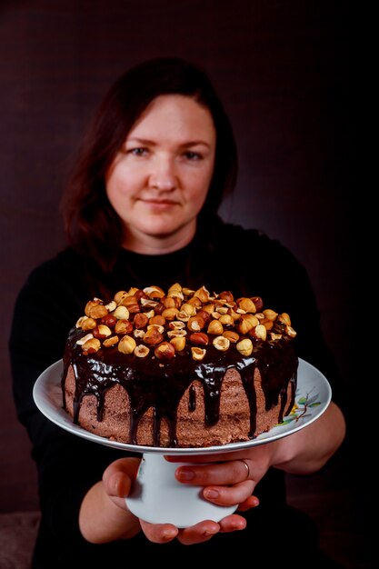 Pasticcere felice che mostra la sua torta fatta in casa in sua mano