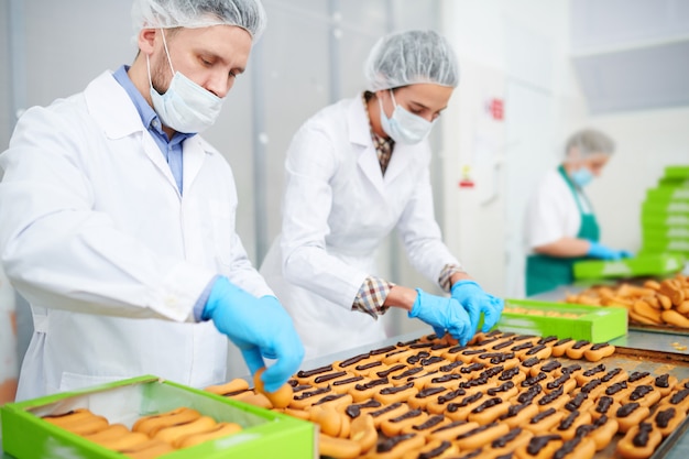 Pasticceri che producono pasticceria con crema al cioccolato