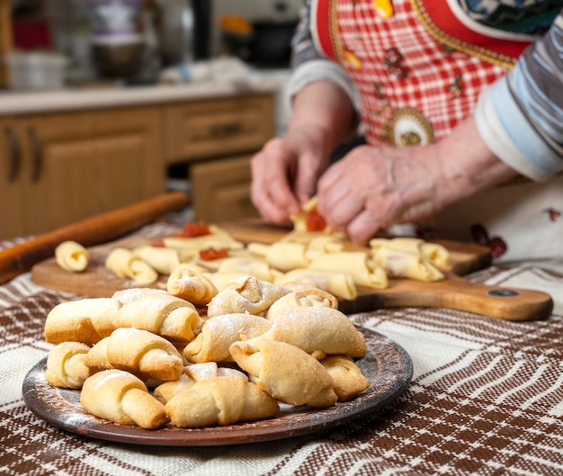 Pasticceria e concetto di cottura. Donna che prepara panini fatti in casa con marmellata a casa