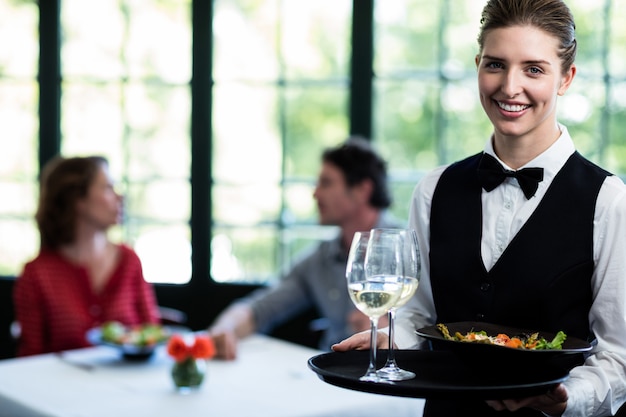 Pasto della cameriera di bar e bicchieri di vino in ristorante