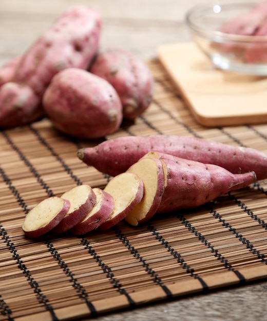 Patata dolce cruda sulla tavola di legno