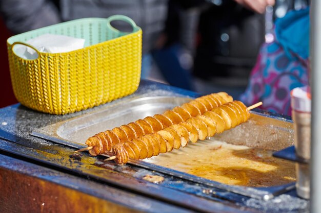 Patata fritta a spirale cotta in olio bollente ricco di grassi e calorie fast food malsano delizioso