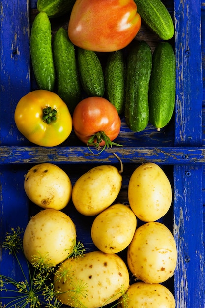 Patata pomodoro e cetriolo verdure fresche su una texture retrò in legno