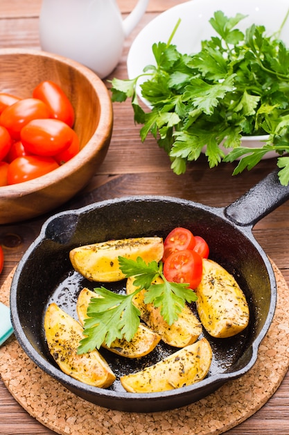 Patate al forno affettate in una padella di ferro