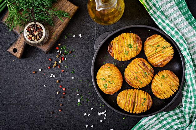 Patate al forno con erbe sul nero.