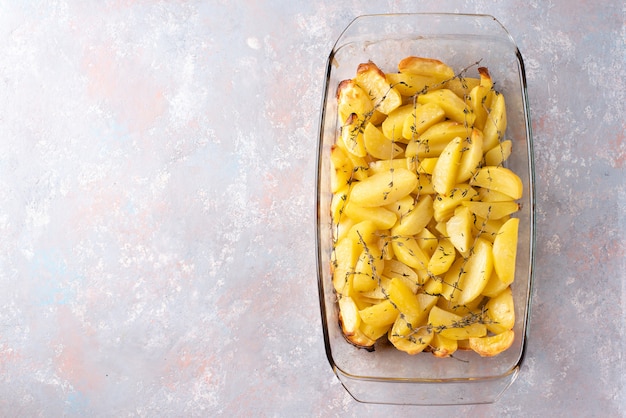 Patate al forno con olio d'oliva, aglio e timo a forma di bicchiere. Vista piana, vista dall'alto.