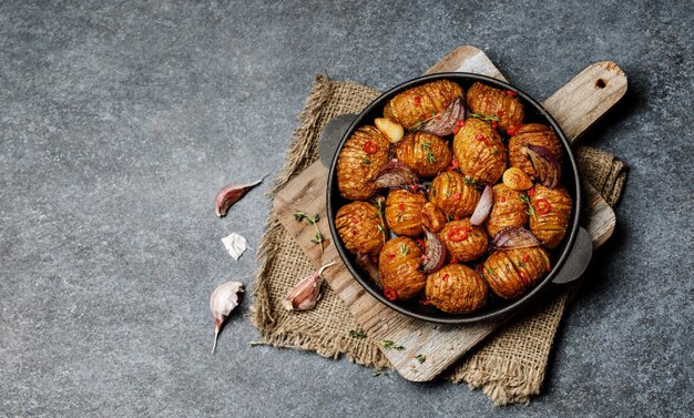 Patate al forno in padella di ghisa con cipolla, aglio ed erbe