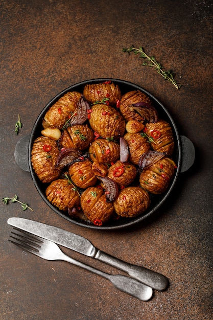 Patate al forno in padella di ghisa con cipolla, aglio ed erbe