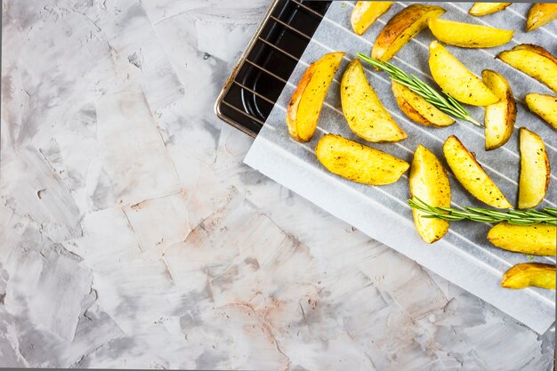 Patate al forno su una teglia con pezzi di spezie e rosmarino