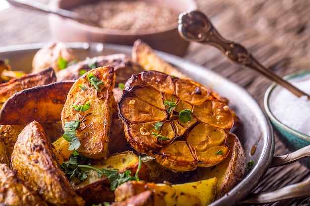 Patate americane. Patate al forno con la buccia. Patate arrosto con aglio spezie sale cumino ed erbe aromatiche.