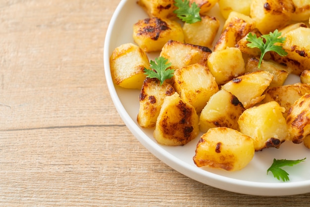 Patate arrosto o alla griglia su piatto bianco