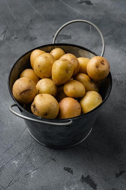 Patate bianche biologiche adagiate su uno sfondo di tavolo in pietra grigia con spazio per la copia del testo