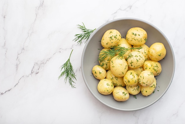 Patate bollite con aneto su sfondo grigio