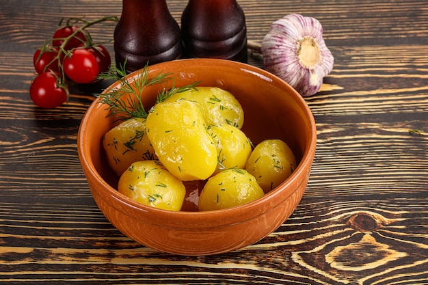 Patate bollite con olio e aneto nel piatto