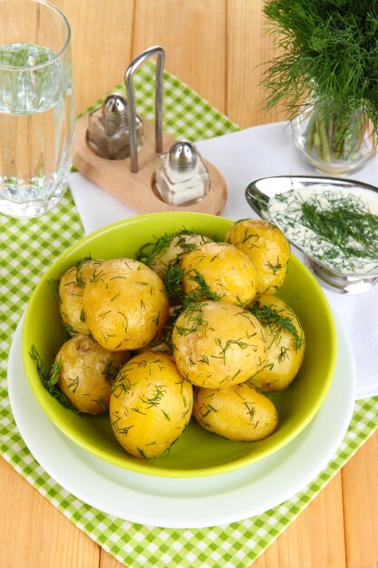 Patate bollite sui piatti sui tovaglioli sulla tavola di legno