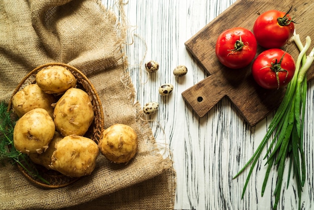 Patate cipolle uova di quaglia pomodori su un tavolo bianco 2