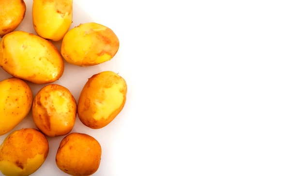 Patate crude su sfondo bianco. Patate fresche su isolato. Vendemmia anticipata. Verdure lavate. Messa a fuoco selettiva. Concetto di abilità culinaria. Posto per un'iscrizione o un logo