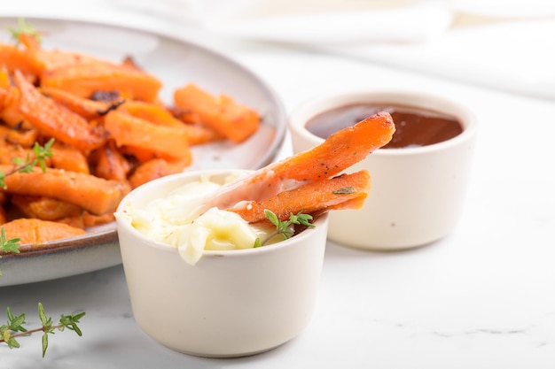 Patate dolci fritte in una ciotola con salsa di maionese zucca arrosto fatta in casa al forno da vicino