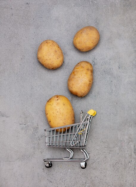 Patate e carrello del supermercato su un tavolo.