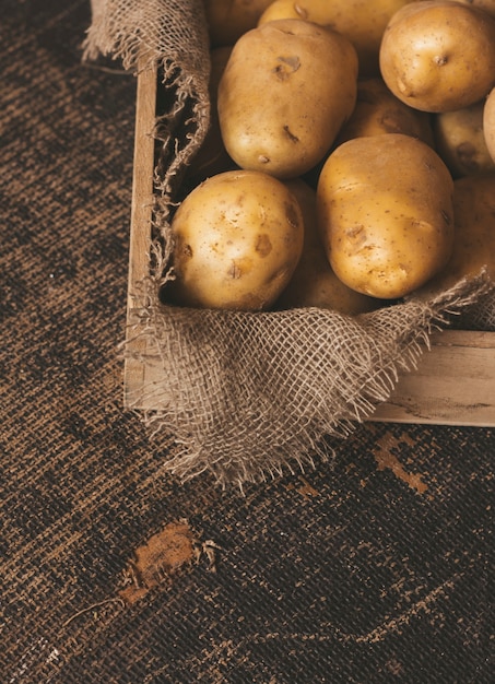 patate fresche su fondo di legno