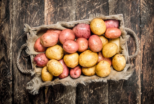 Patate fresche su un vassoio di legno