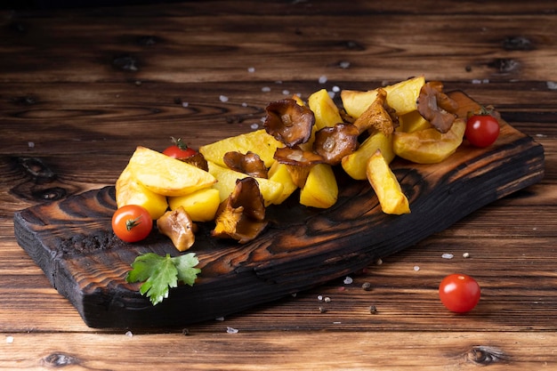 Patate fritte con finferli su tavola di legno sul tavolo