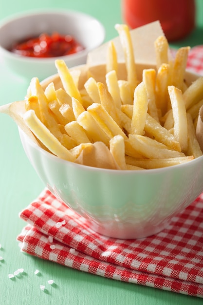 Patate fritte con ketchup sopra fondo verde