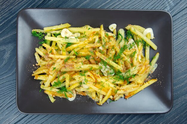 Patate fritte cotte con erbe e verdure su un piatto