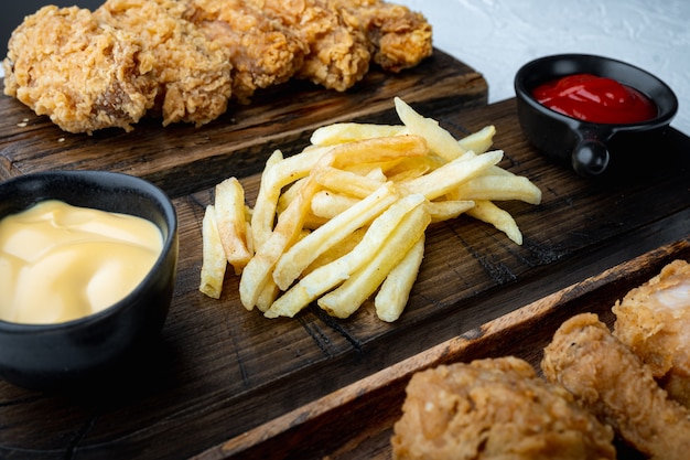 Patate fritte croccanti con pollo impanato su bianco