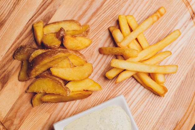 Patate fritte fritte su un piatto sul tavolo di legno.