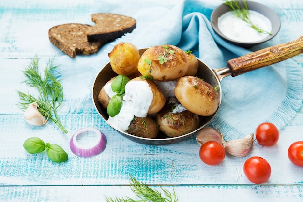 Patate fritte in padella con panna acida su spazio rustico