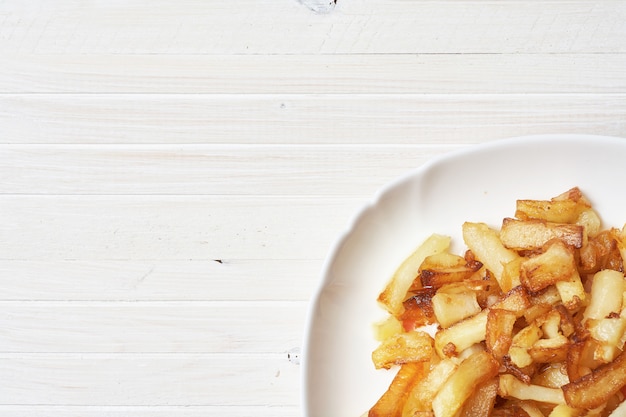 Patate fritte in un piatto bianco