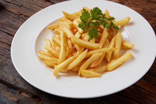 Patate fritte in una ciotola su un fondo di legno