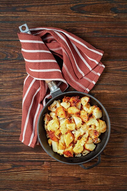 Patate fritte in una padella su una tavola di legno. Vista dall'alto