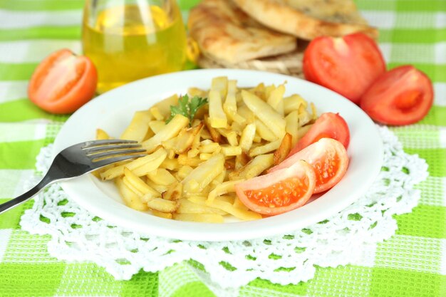 Patate fritte Ruddy sul piatto sul primo piano di legno della tavola