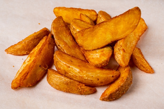 Patate fritte rustiche su una priorità bassa di carta.