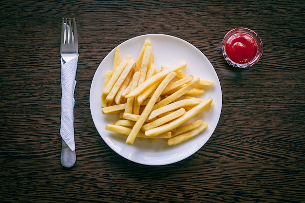 Patate fritte sul piatto bianco con ketchup