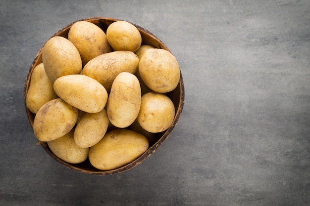 Patate novelle sulla ciotola, sfondo grigio.