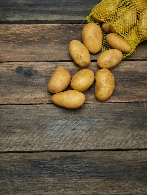 Patate sul vecchio tavolo di legno.