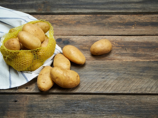 Patate sul vecchio tavolo di legno.