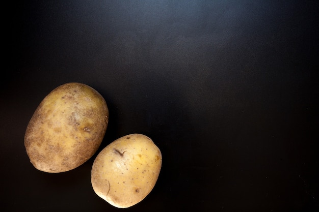 Patate sulla tavola nera, fondo dell'alimento. Patate isolate