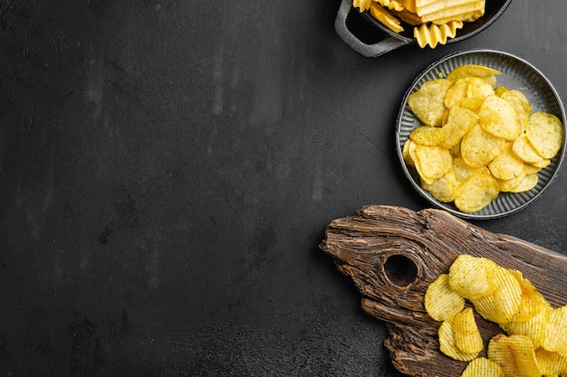 Patatine fritte al gusto di cipolla e panna acida su sfondo nero tavolo in pietra scura vista dall'alto piatto con spazio per la copia del testo