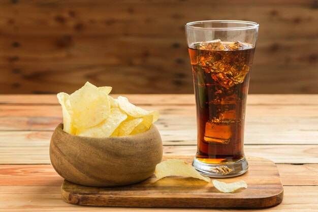 Patatine fritte con cola su un fondo di legno