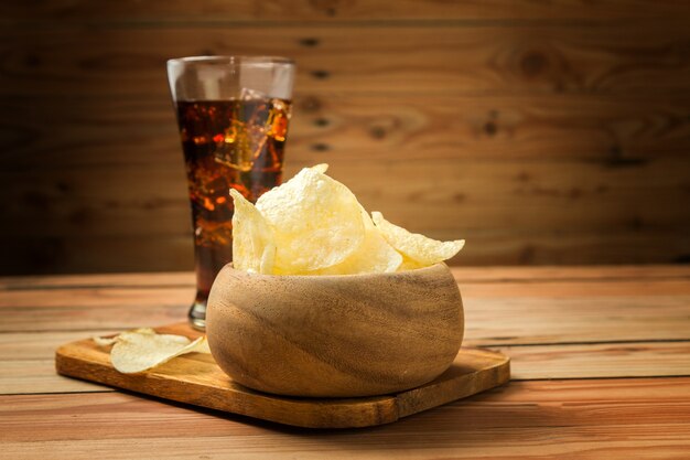 Patatine fritte con cola su un fondo di legno