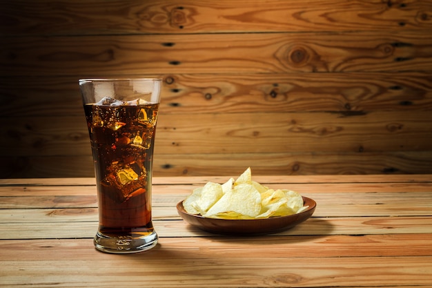 Patatine fritte con cola su un fondo di legno