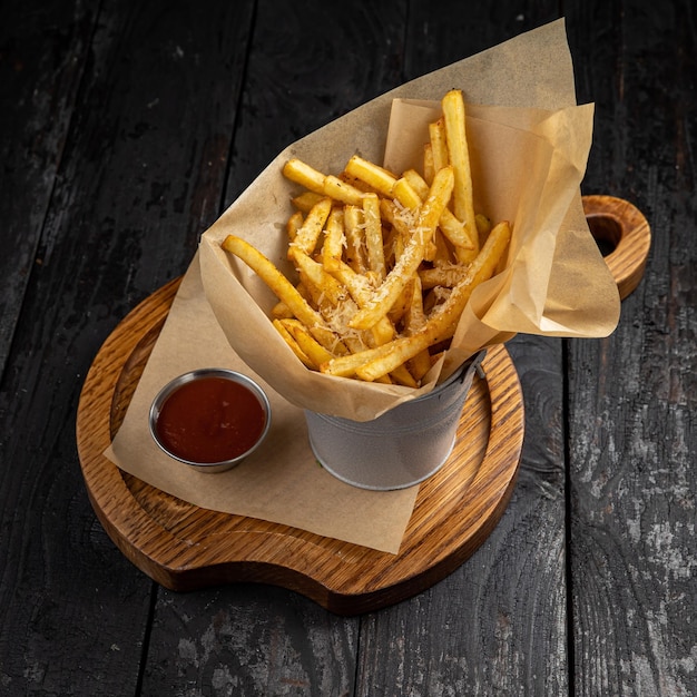 Patatine fritte con salsa di pomodoro su un tavolo di legno scuro