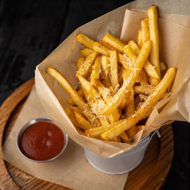 Patatine fritte con salsa di pomodoro su un tavolo di legno scuro