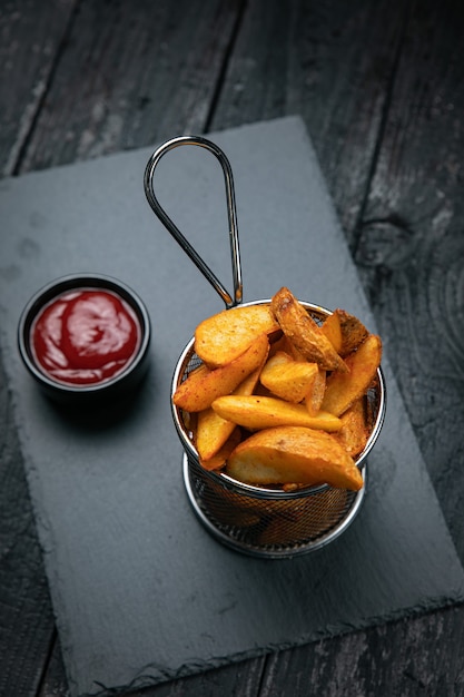 patatine fritte con salsa su sfondo scuro