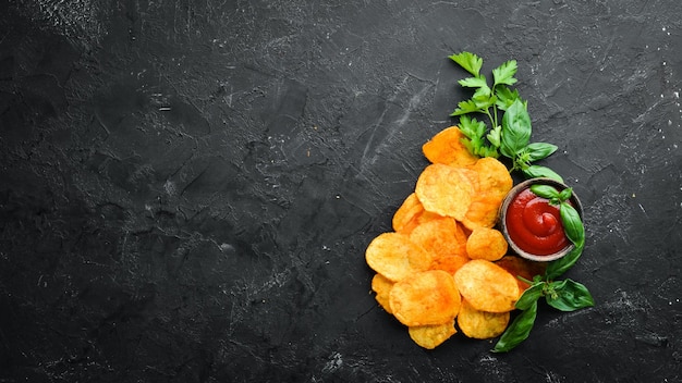 Patatine fritte con spezie su sfondo nero Snack alla birra Vista dall'alto Spazio libero per il testo