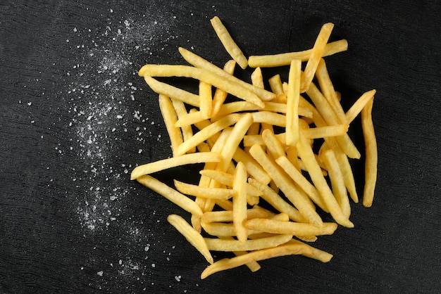 Patatine fritte e sale su sfondo scuro Vista dall'alto Fast food